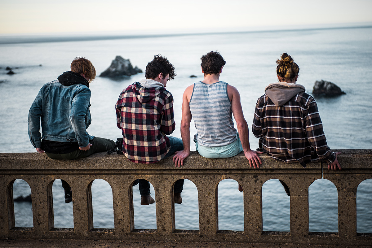 Young adults sitting on bridge