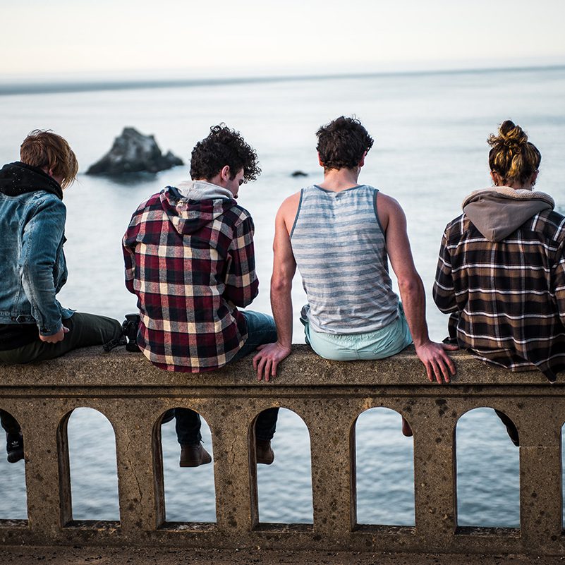 Young adults sitting on bridge